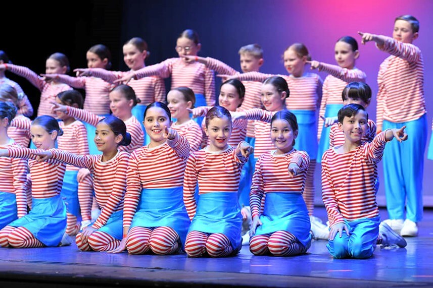 Primary School Dance Group performing a Where's Wally themed dance on stage at Combined Schools Concerts.